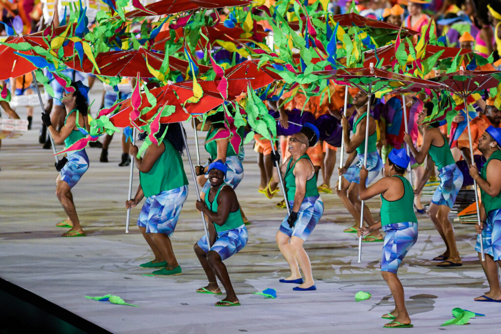 Artistas de la ceremonia inaugural bailan con sombrillas de colores en el centro del estadio Maracaná de Brasil.