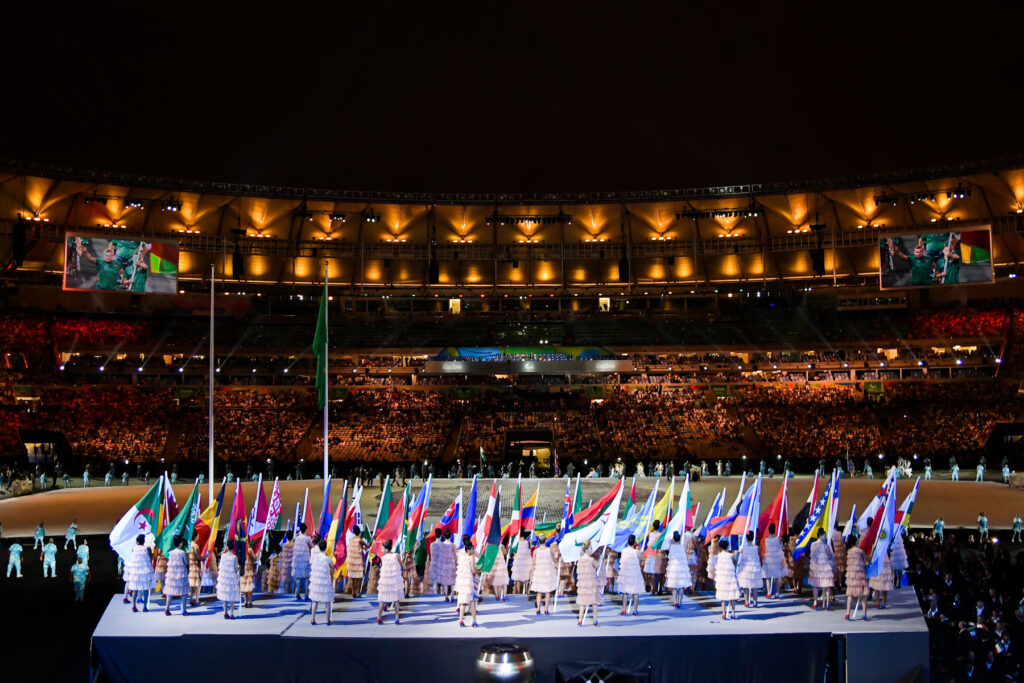 Un grupo de mujeres sostiene las banderas de todos los países participantes en los Juegos Paralímpicos de Río 2016.