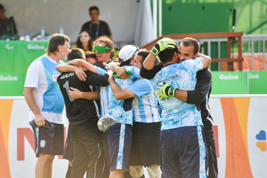 La Selección Argentina masculina de fútbol para ciegos se abrazándose con alegría.